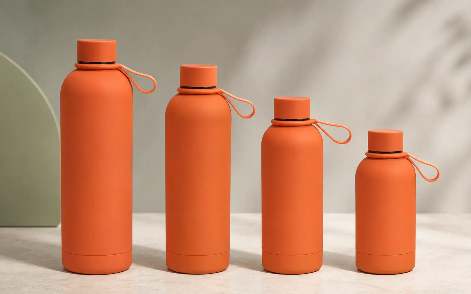 Orange vacuum flasks in four sizes with loop caps.