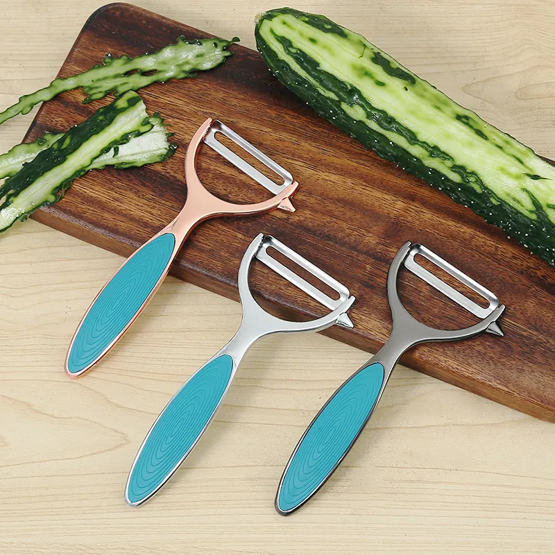 MX-ZP01 three Zinc Alloy Peelers in rose gold, silver, and grey with turquoise handles on a wooden board next to sliced cucumbers.
