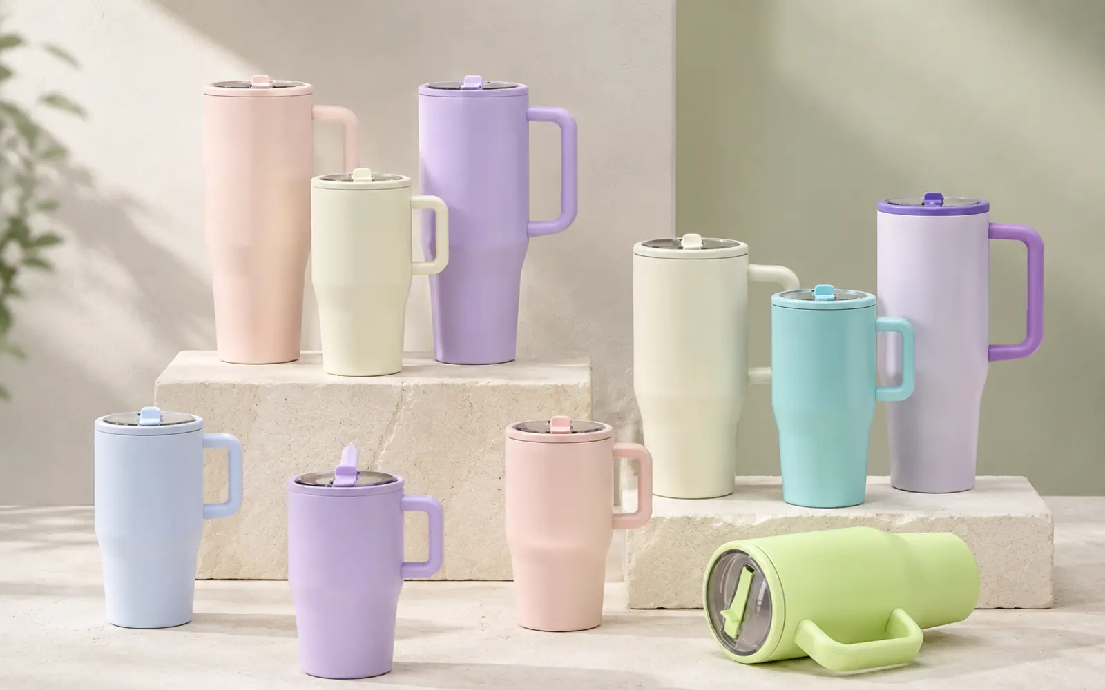 Handled travel mugs with sliding lids in pastel colours.