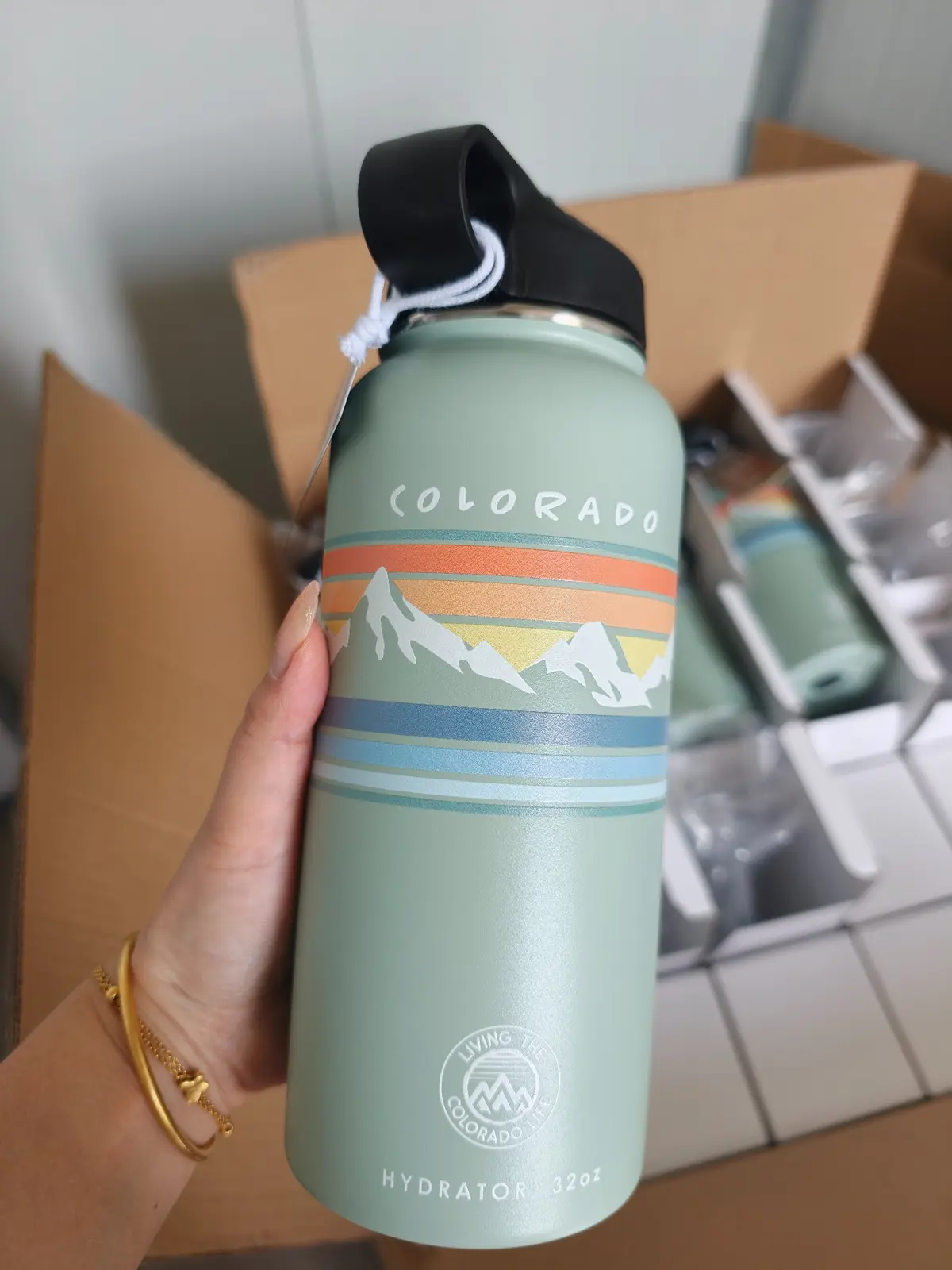 Insulated drinkware bottle with a large-area custom printed graphic, held in a workshop