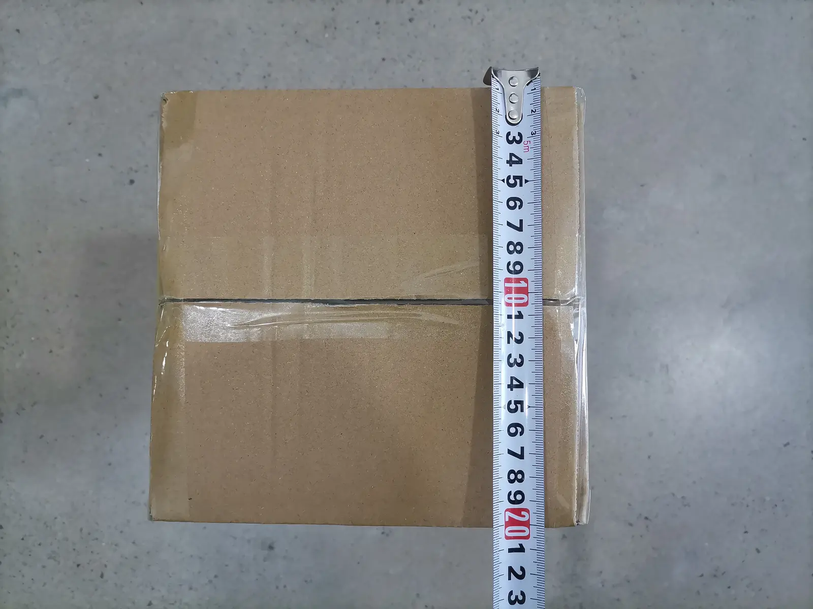 MOWXI team measuring the outer-carton width for a packed MX-500AB batch